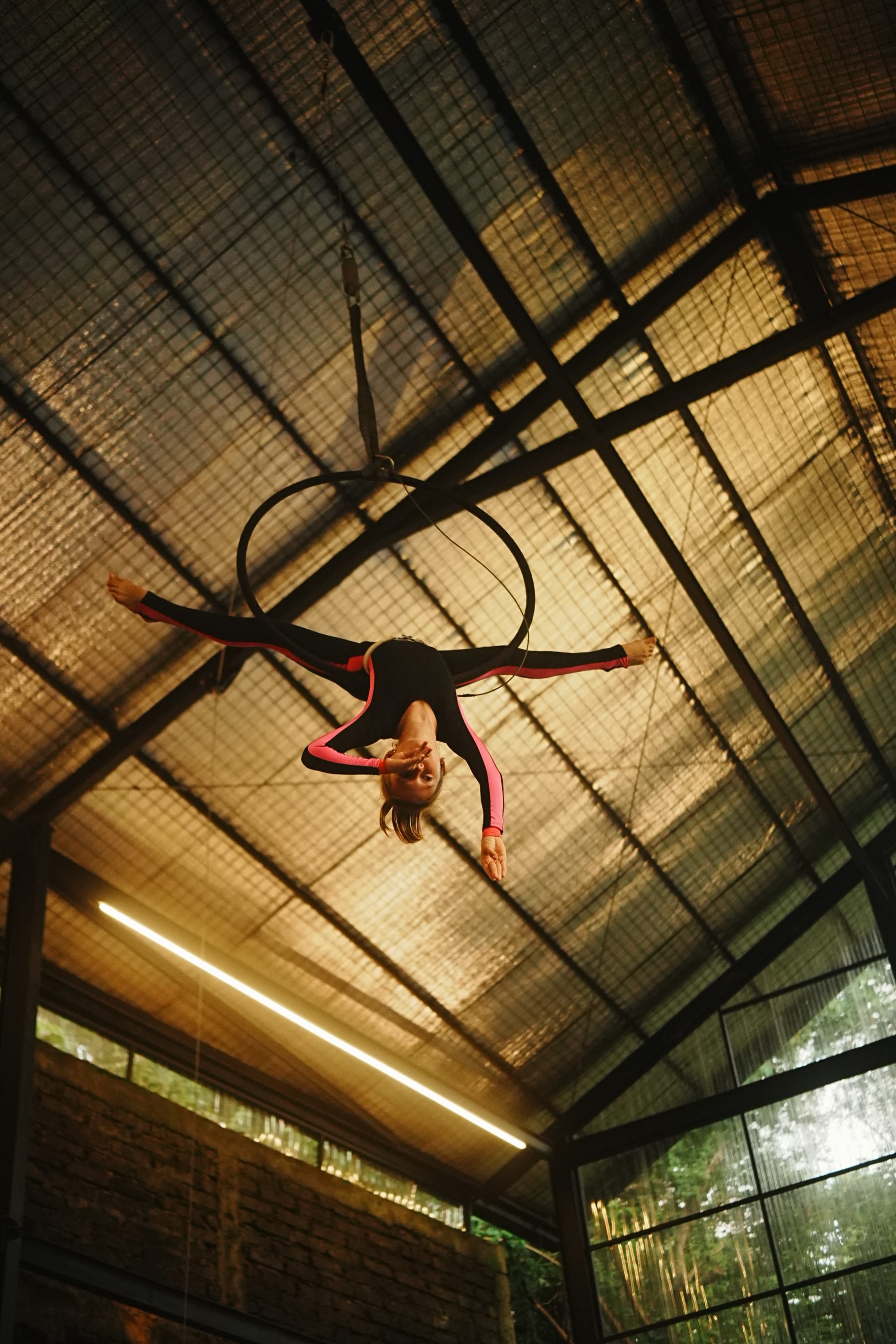 Aerialist working high under the roof of the hall