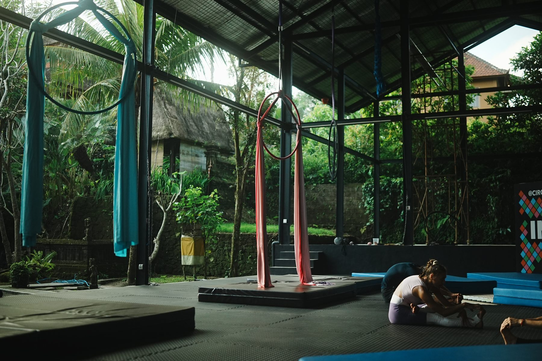 The open-air aerial hall with silks and mats